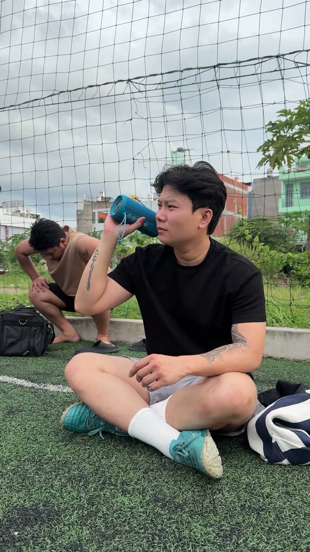 Ngồi ngoài sân bóng, loa để bên cạnh